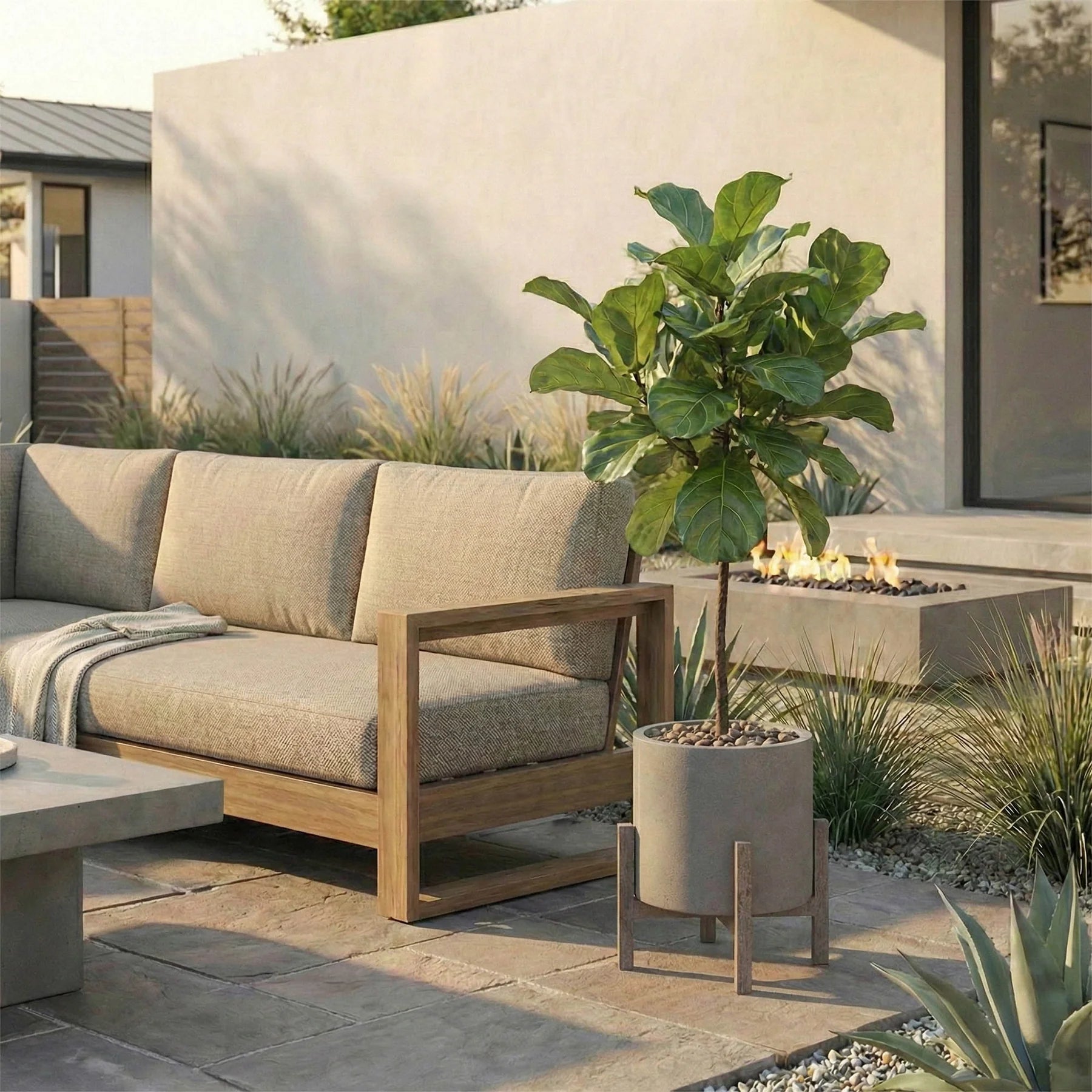 Outdoor patio with beige sofa, potted plant, and fire pit area.